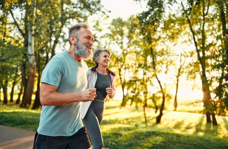 To personer jogger utendørs i sommersol